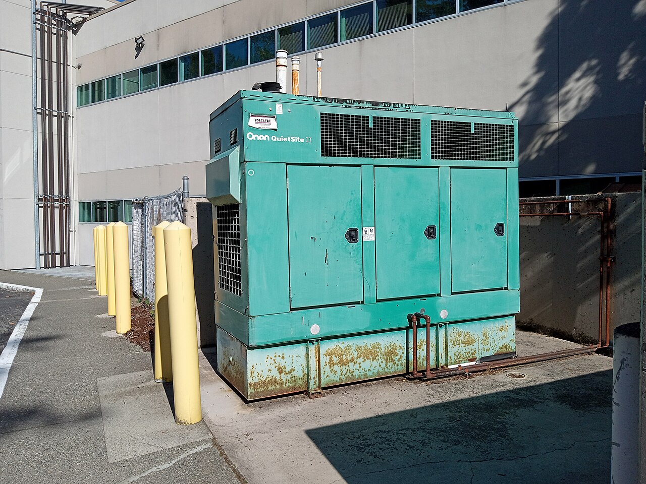 Gerador fixo instalado no exterior, junto à parede de um edifício