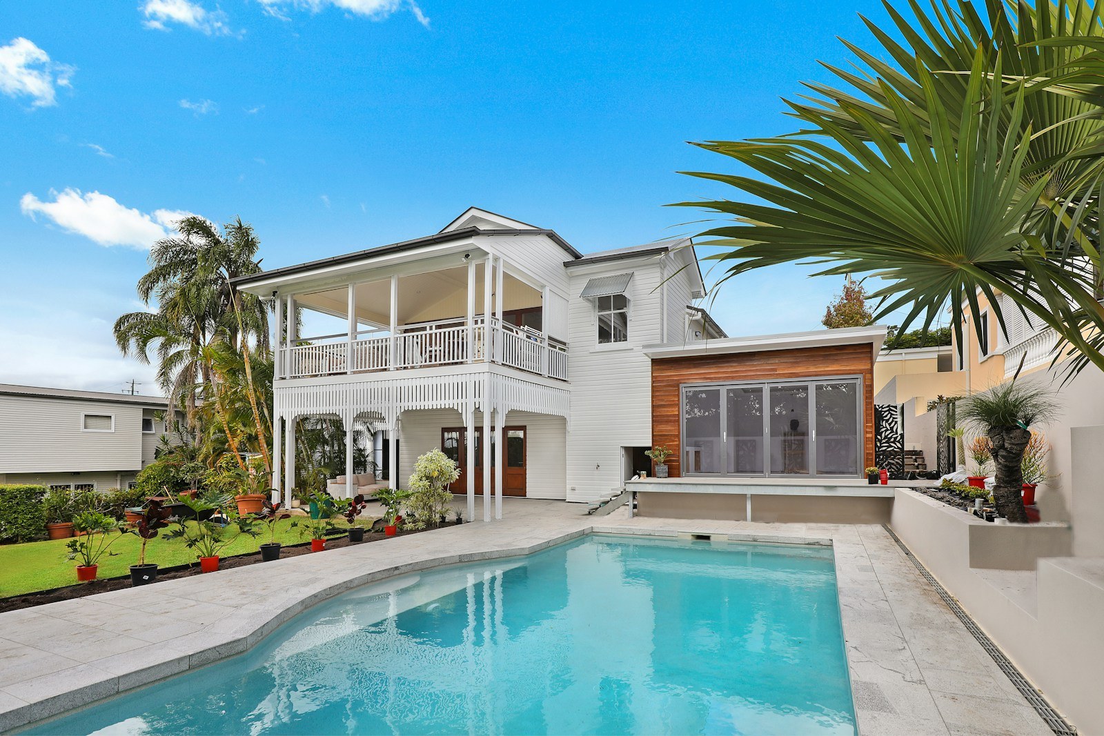 Piscina exterior e terraço junto a uma casa.